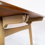 Dining table in teak and oak with extensions designed by Hans J. Wegner