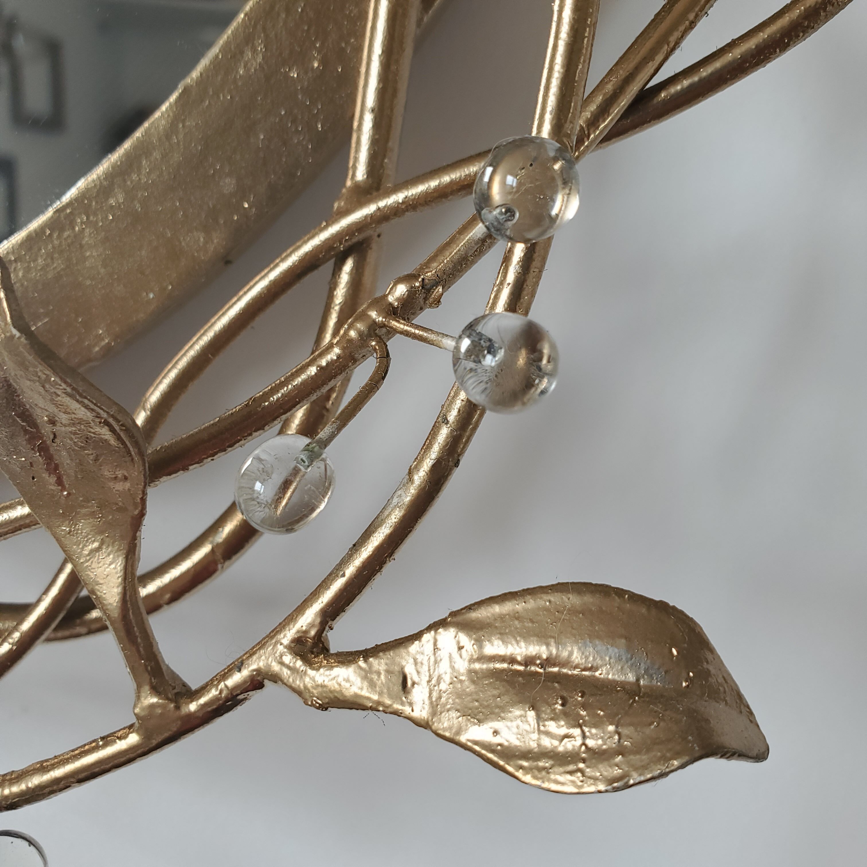 Round mirror in gilded wrought iron and leaves