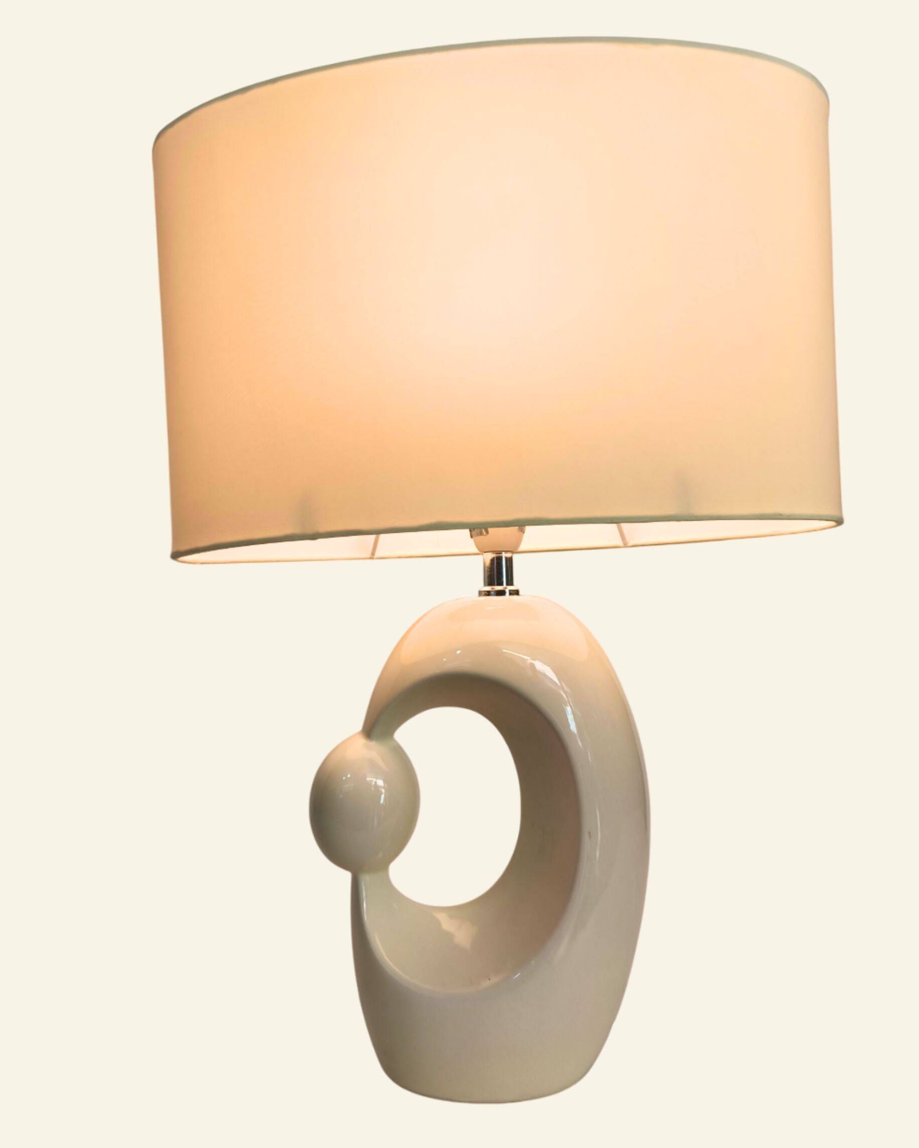 Cream ceramic table lamp with a mid-century design, featuring a lampshade.