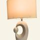 Cream ceramic table lamp with a mid-century design, featuring a lampshade.