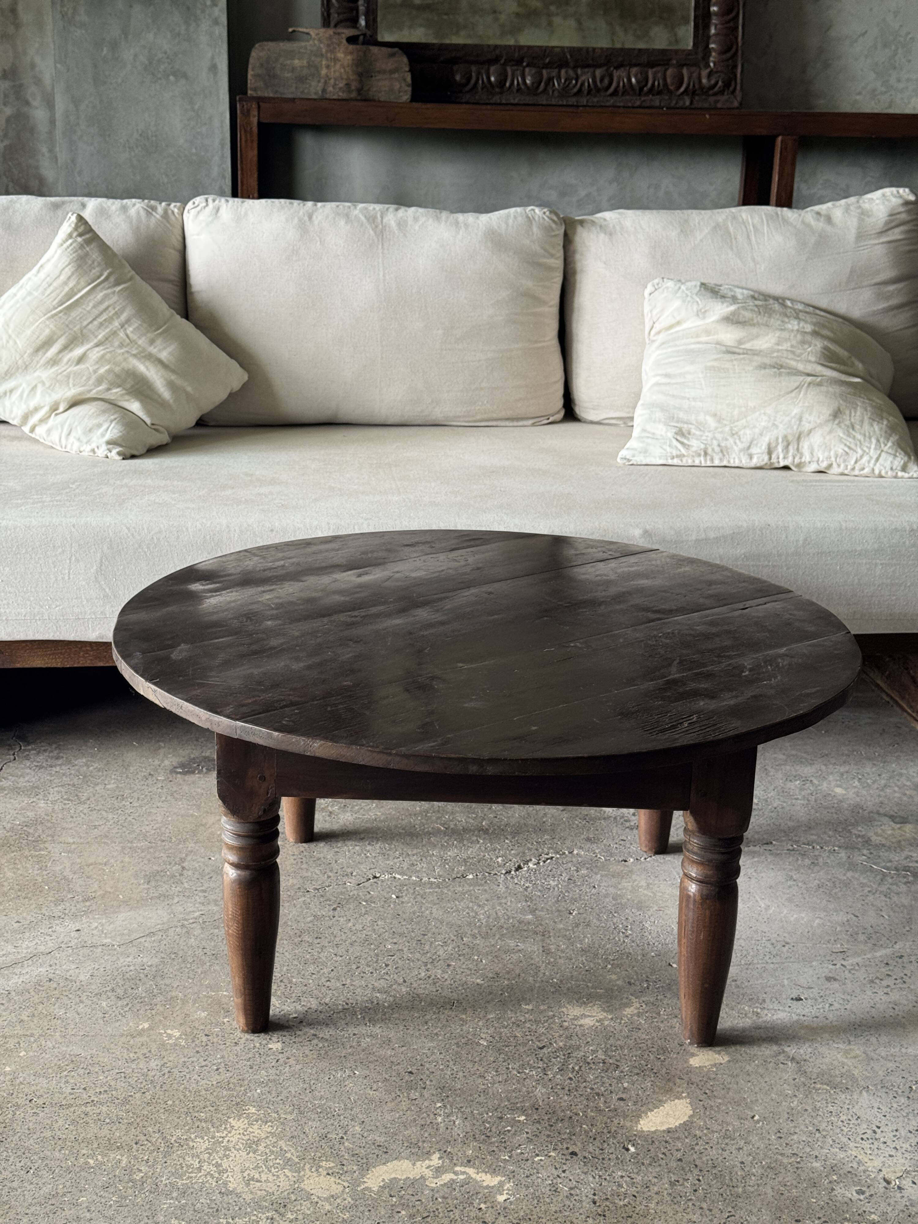Coffee table, round antique Indonesian teak table with straight legs.
