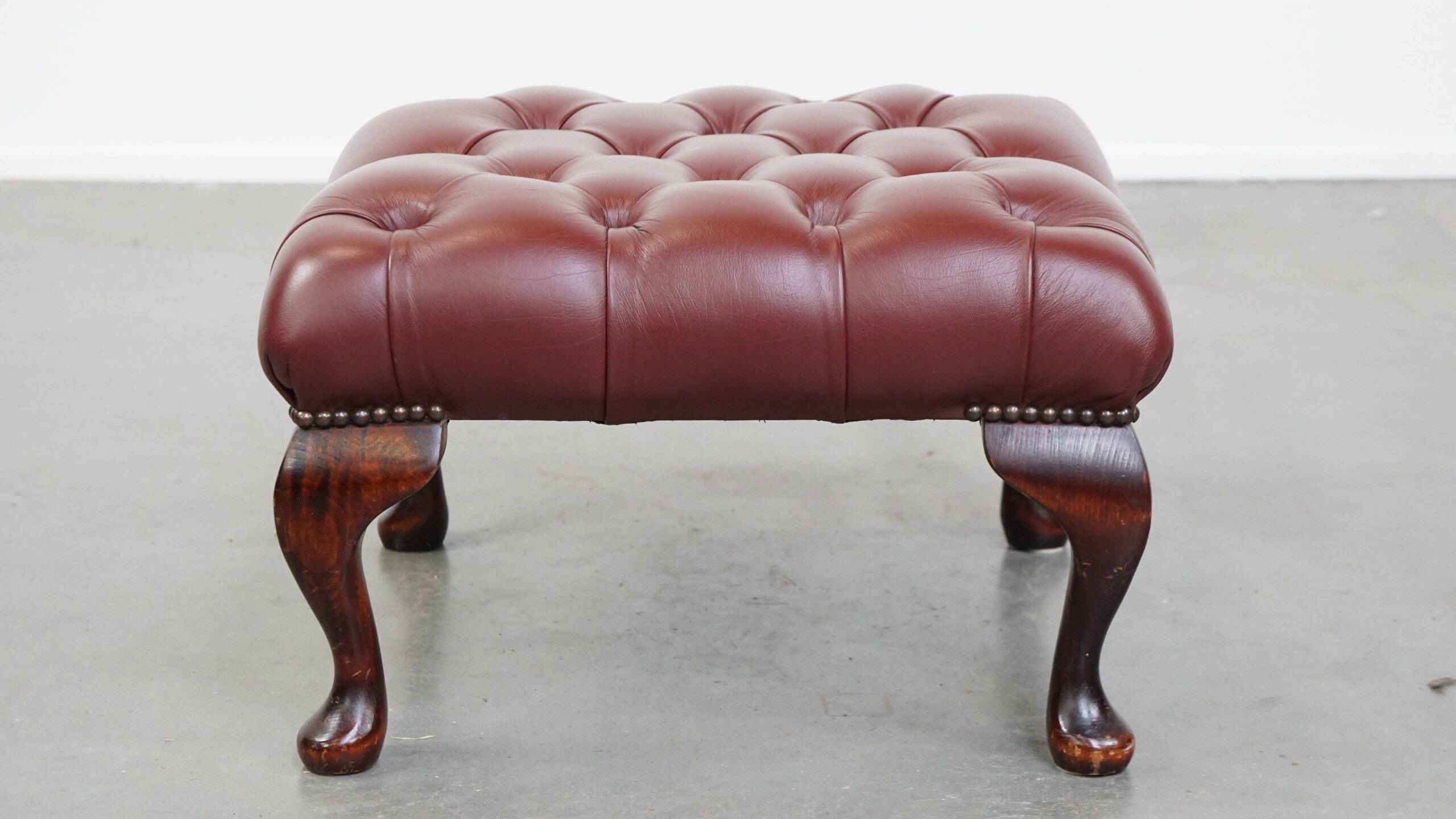 In very good condition elegant red/brown chesterfield ottoman made of cow leather
