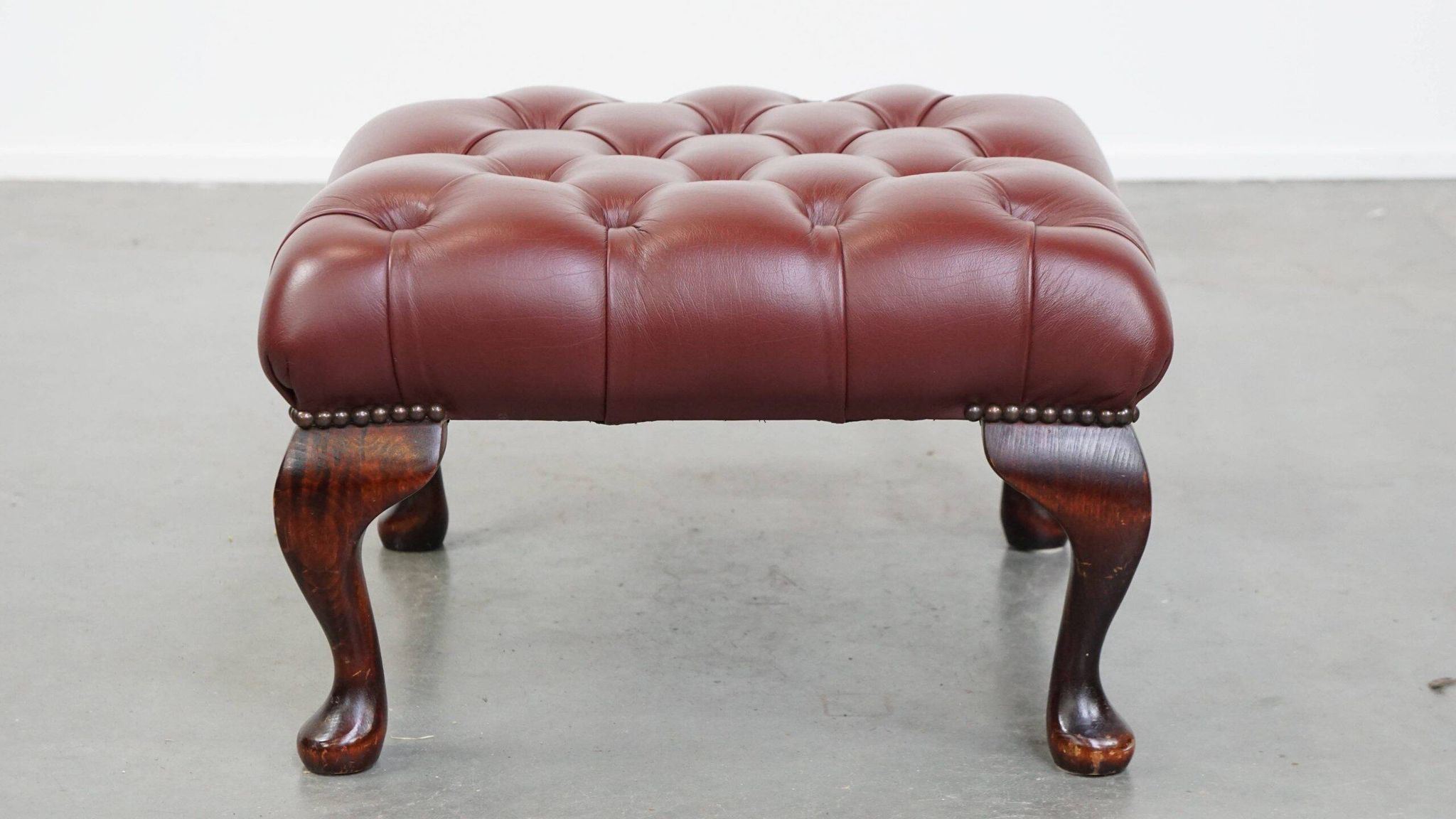 In very good condition elegant red/brown chesterfield ottoman made of cow leather