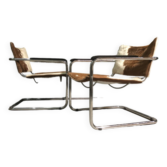 A pair of cow hide 1980's cantilever lounge chairs.