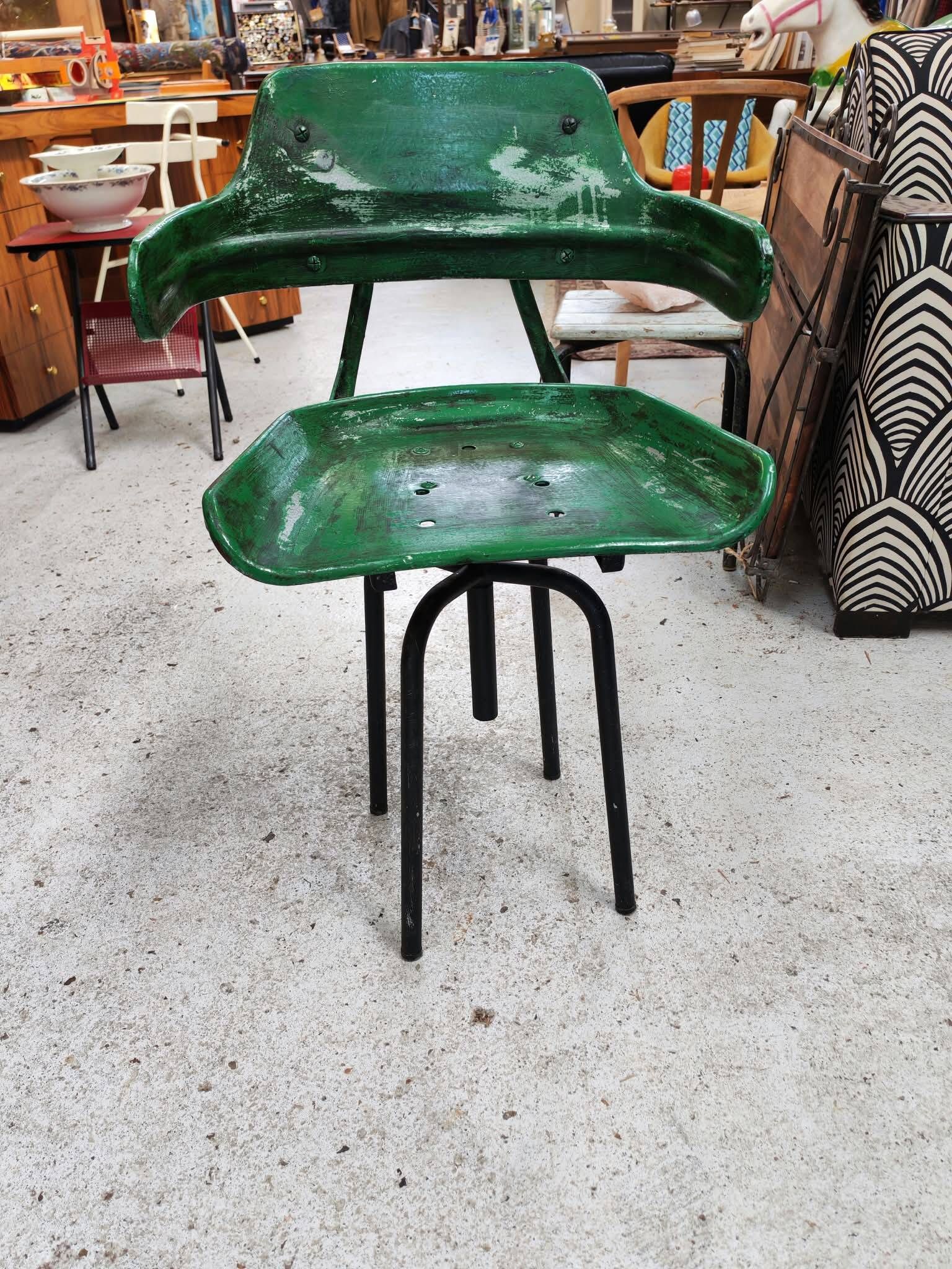 Vintage swivel workshop chair in green pressed sheet metal with a folding backrest.