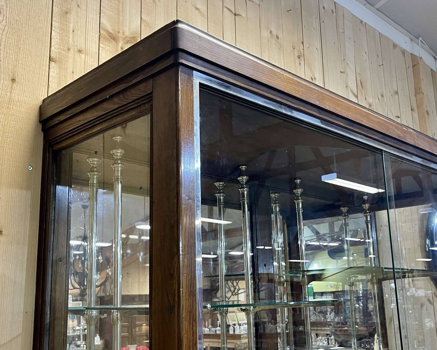 Early 20th-century shop display cabinet in oak with sliding doors.