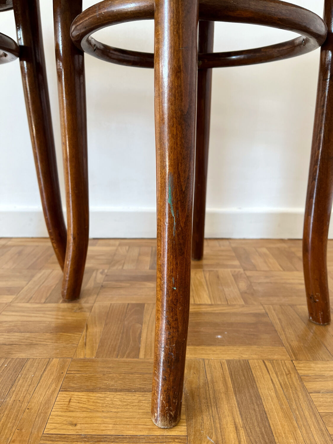 2 antique bistro stools with curved wood and caning effect.