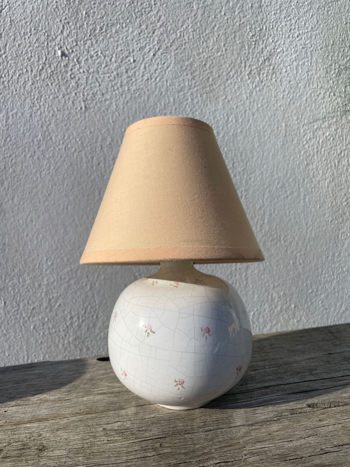 Small cracked white ceramic lamp with flowers.