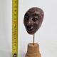 Expressive sculpted head in patinated terracotta on wooden base, 14 cm