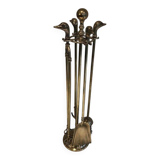 Neoclassical brass fire accessory with duck head decorations.
