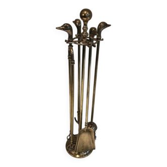Neoclassical brass fire accessory with duck head decorations.