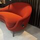 Two-seater sofa in red/orange boucle fabric.
