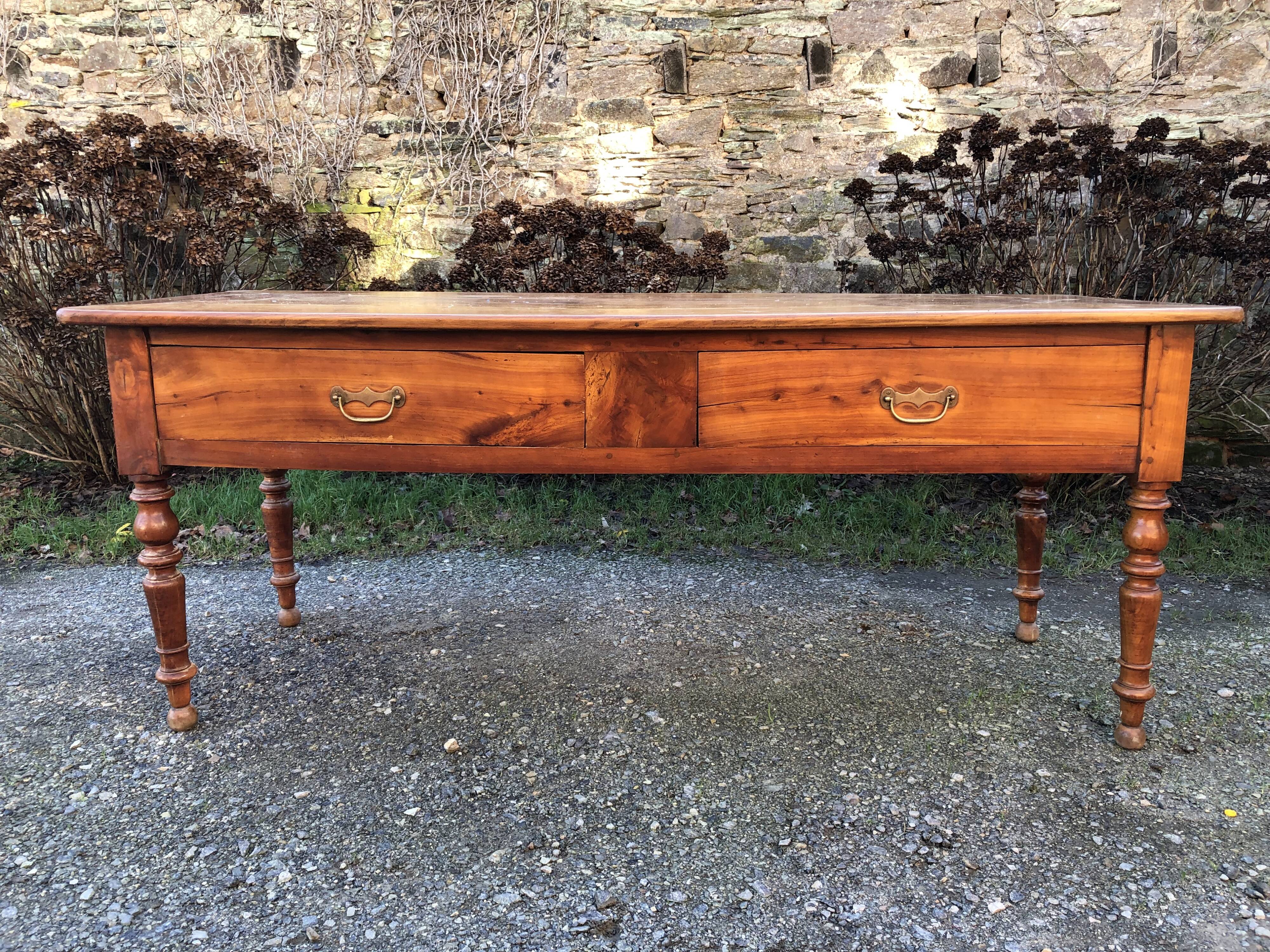 Antique cherry farmhouse table with turned legs and 2 drawers.