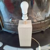 High foot of lace-up desing lamp, off-white background and beige patterns.
