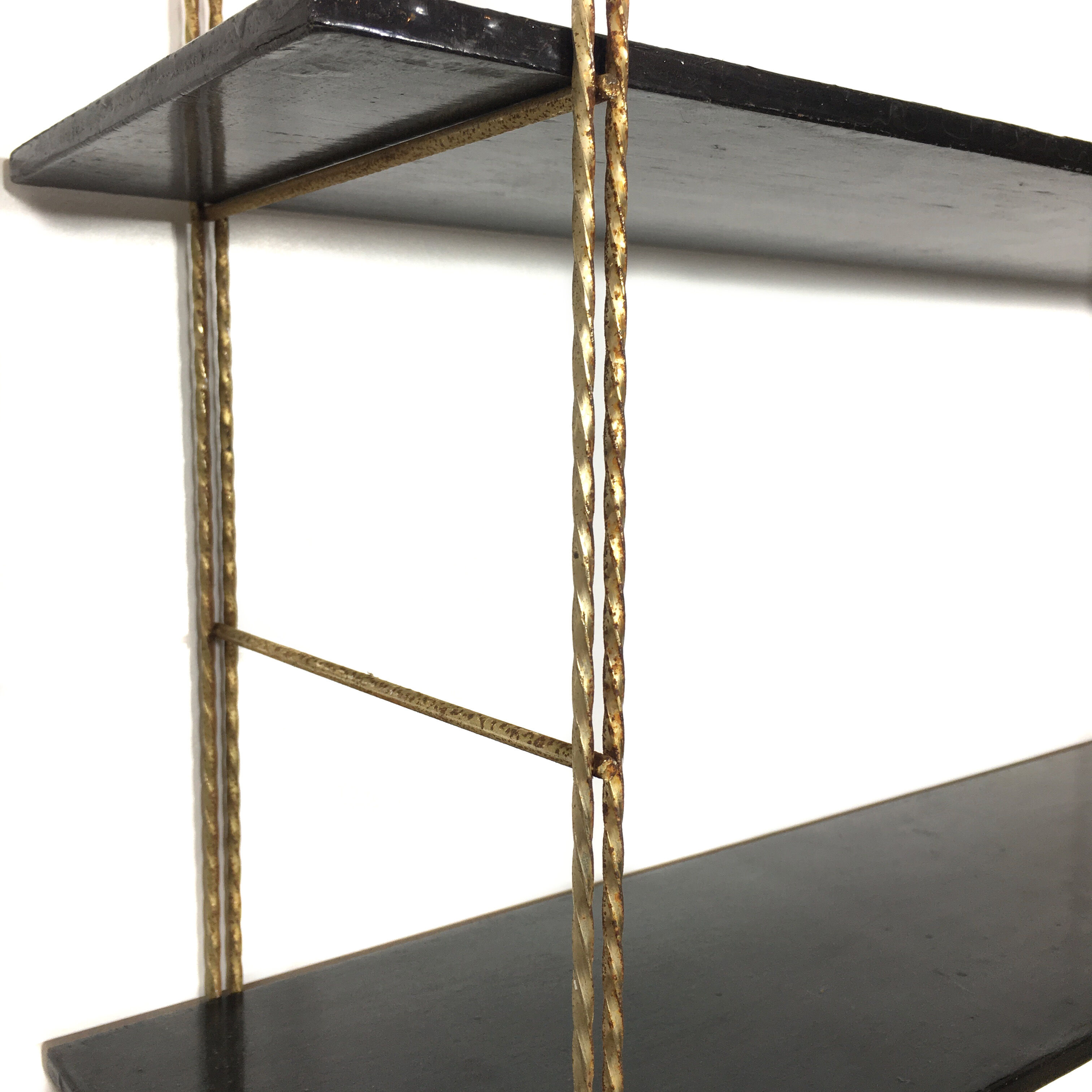 String gold metal shelf and black wood