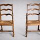 Pair of rustic antique armchairs in wood and woven straw.