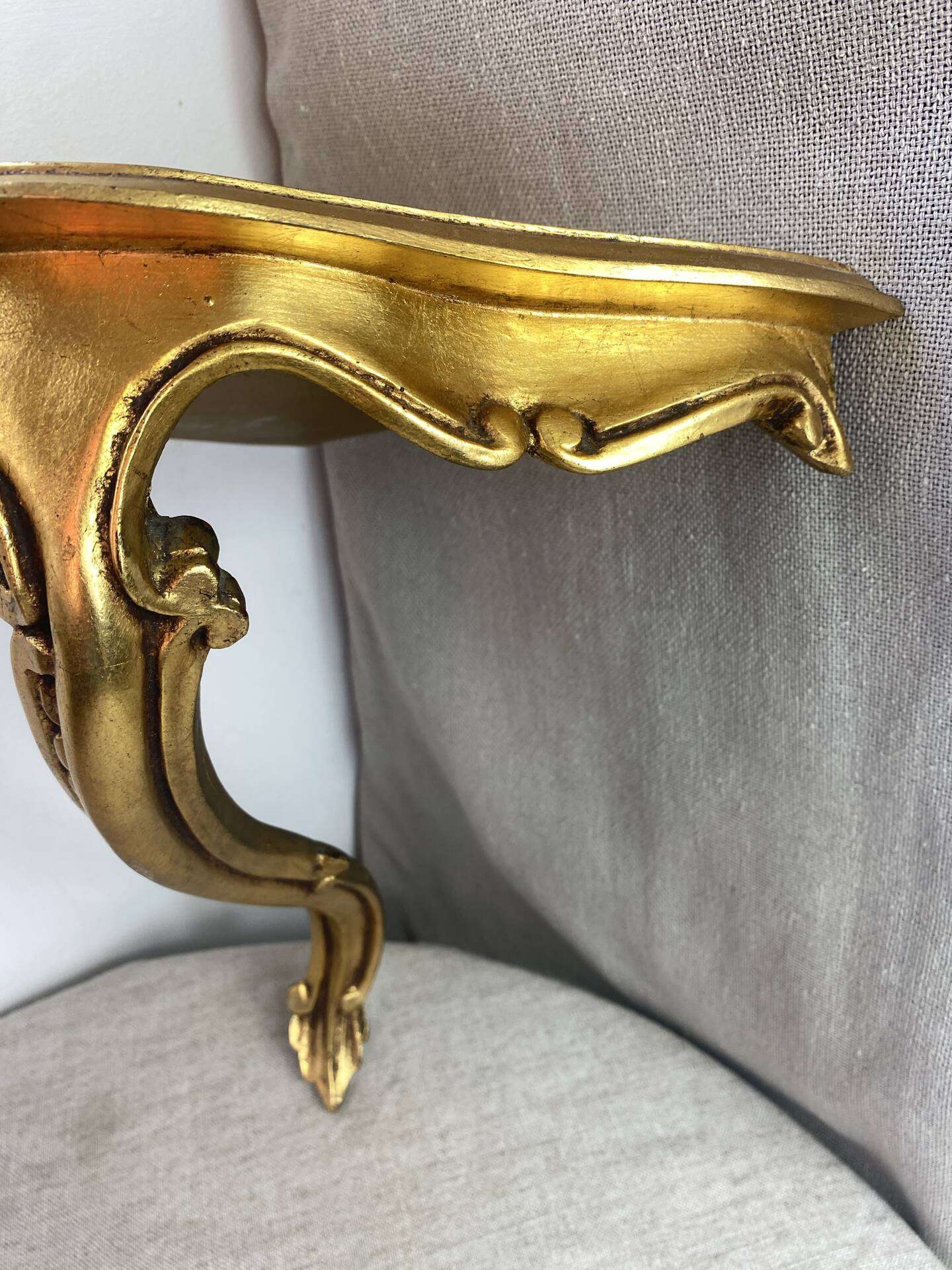 Small corner console in resin with a gold finish.