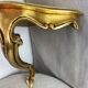 Small corner console in resin with a gold finish.