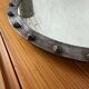 Brutalist round mirror with wrought iron and studs.
