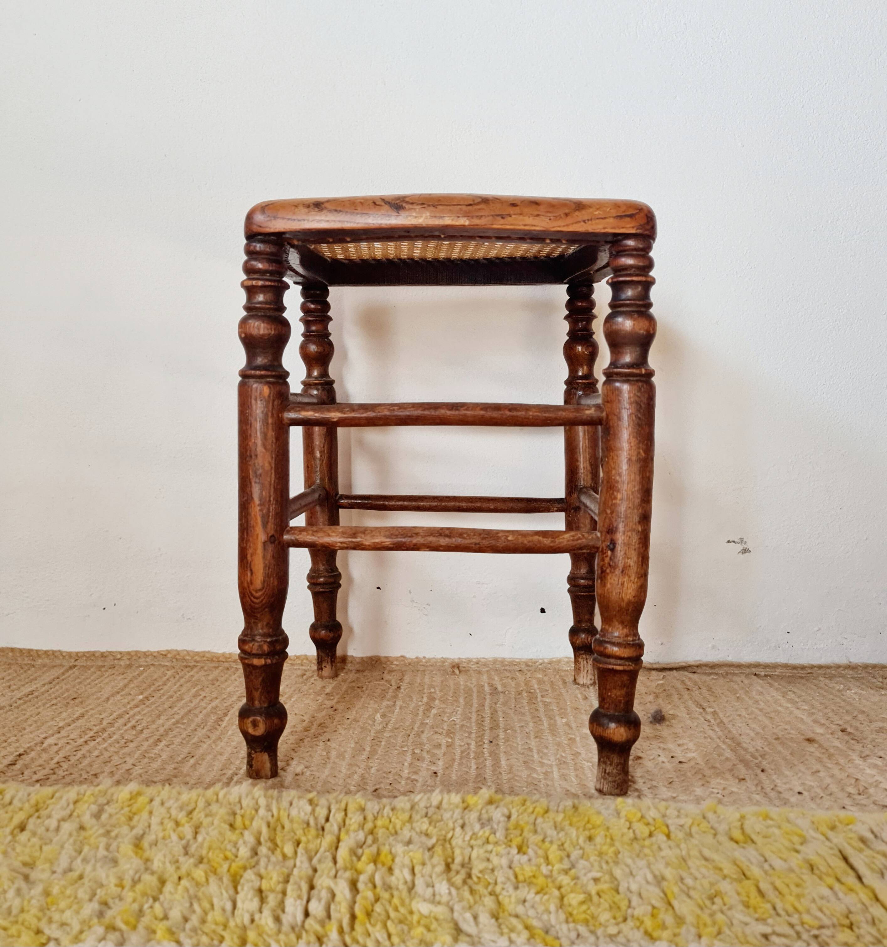 Wooden stool with cane seat