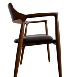 Curved wooden dining chair with brown leather seat