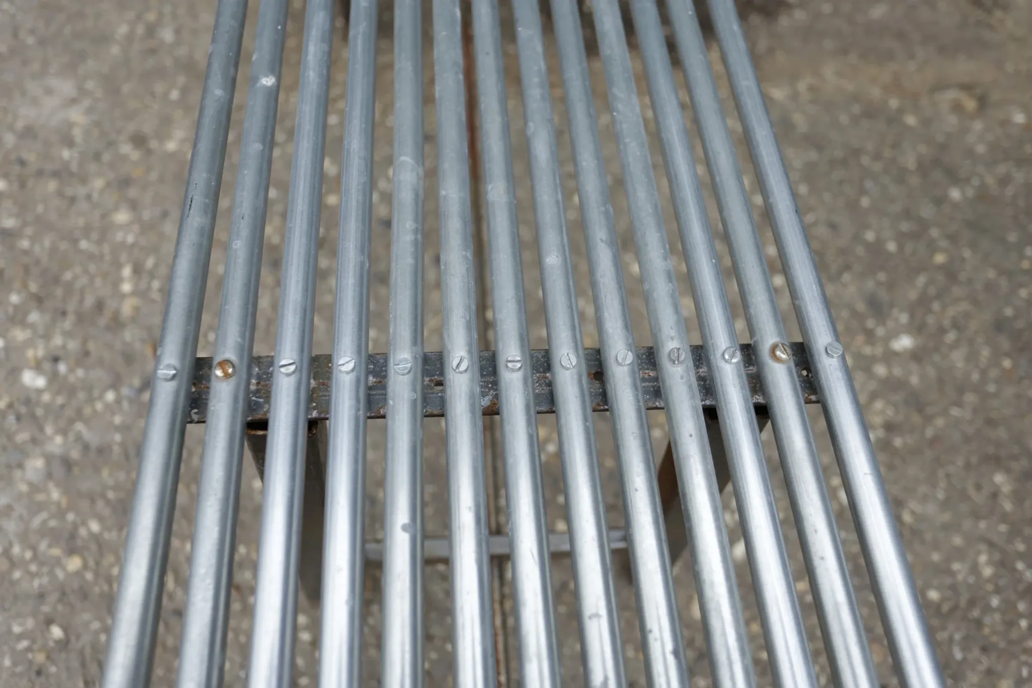 Long metal bench with tubular seat