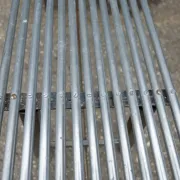 Long metal bench with tubular seat