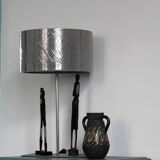 Metal lamp with metallic grey lampshade and with magnetized African wooden statuettes