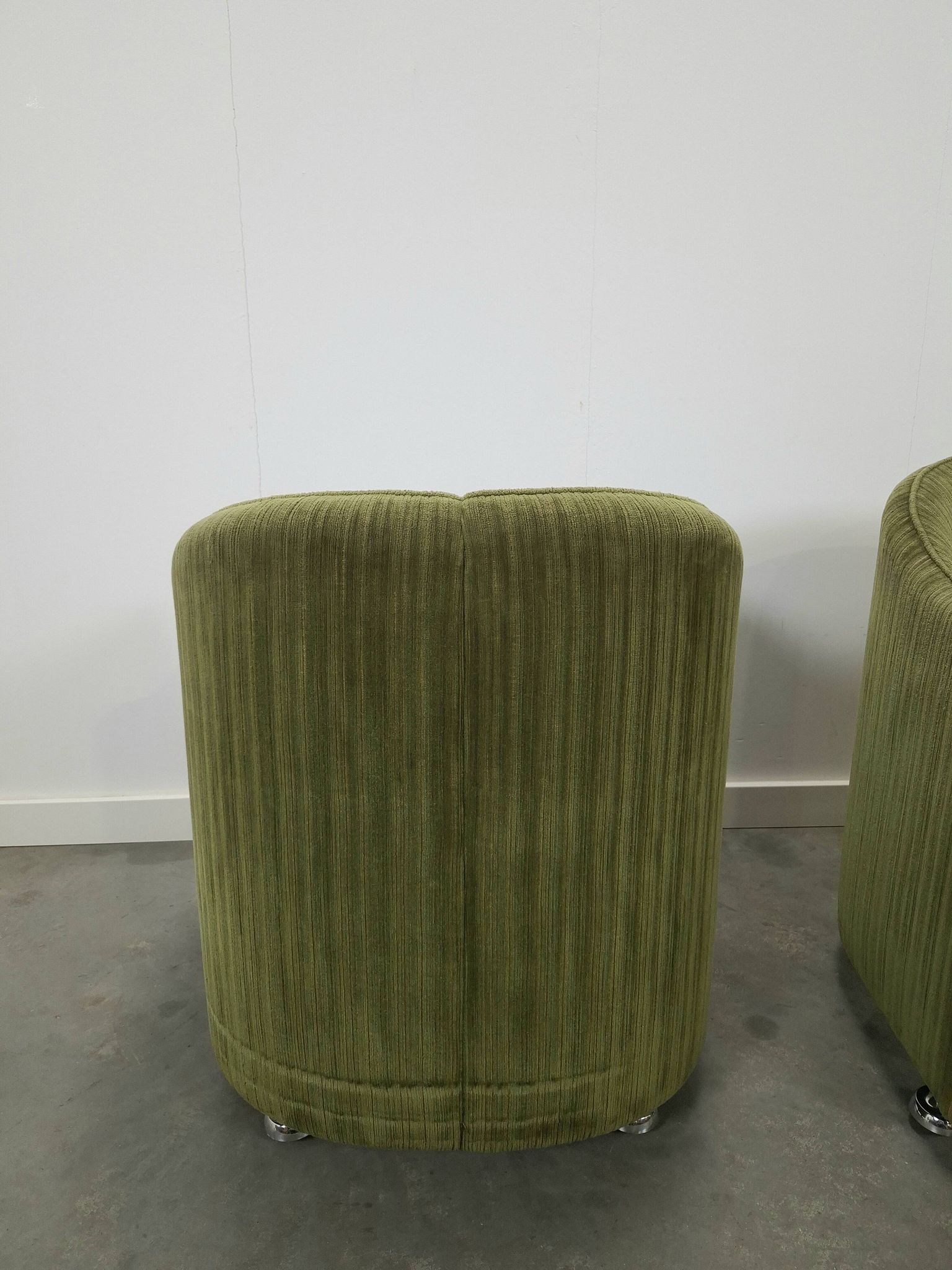 Chaises de cocktail vertes avec des roues chromées.