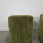 Chaises de cocktail vertes avec des roues chromées.