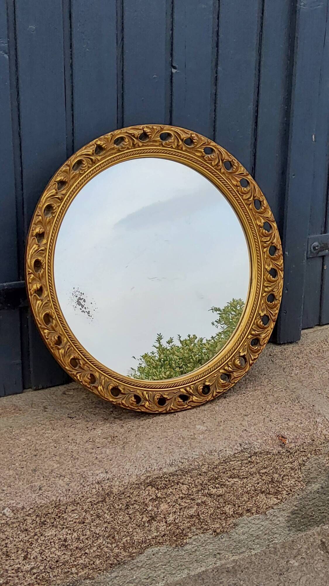 Round neoclassical style mirror in wood and gilded stucco from the 1950s