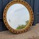 Round neoclassical style mirror in wood and gilded stucco from the 1950s