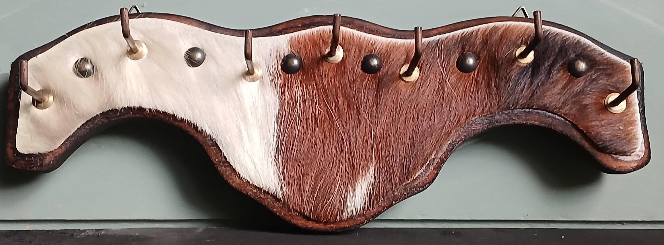 Wooden coat rack, nails & cowhide