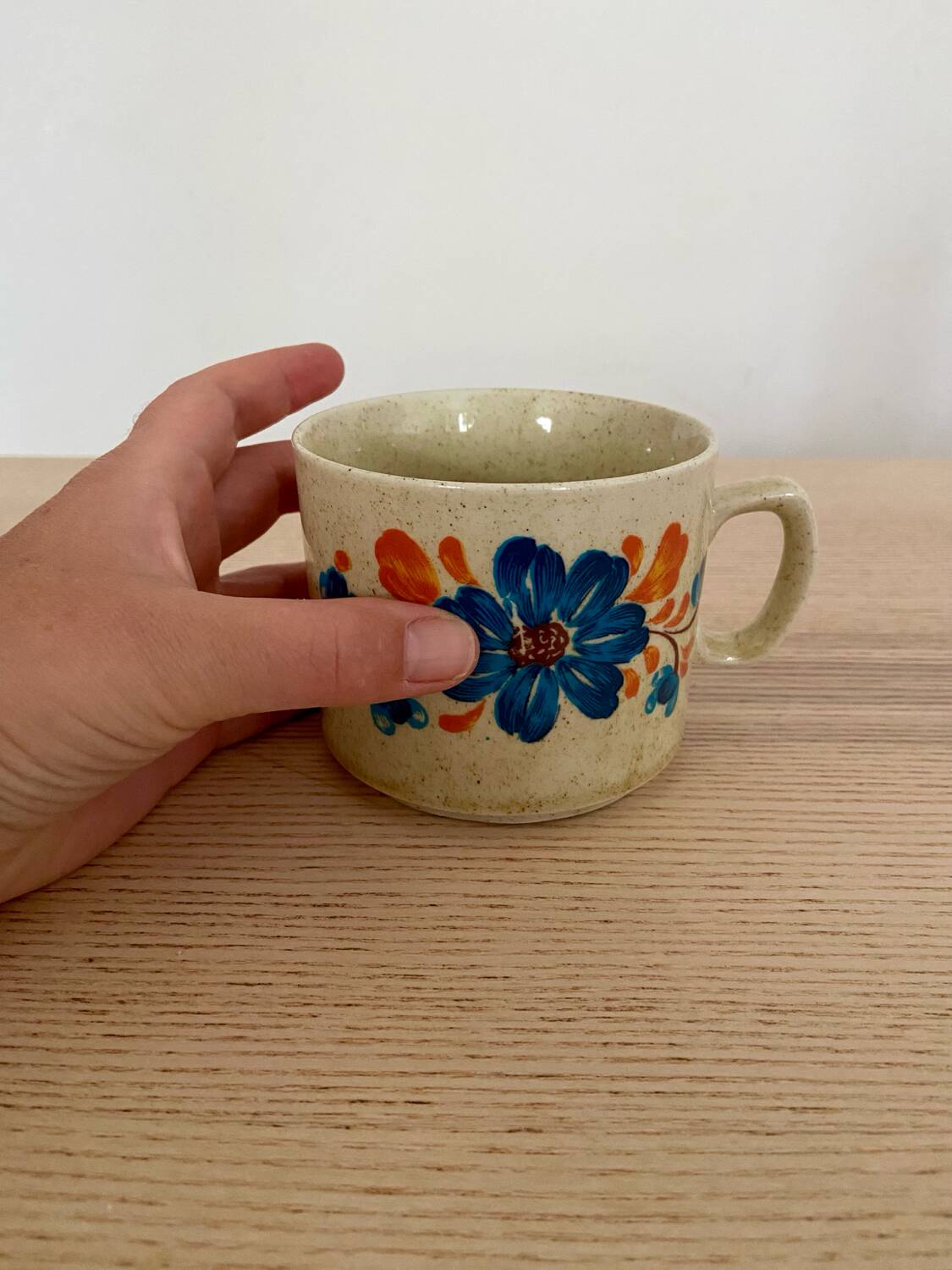 Speckled stoneware cup with blue flower