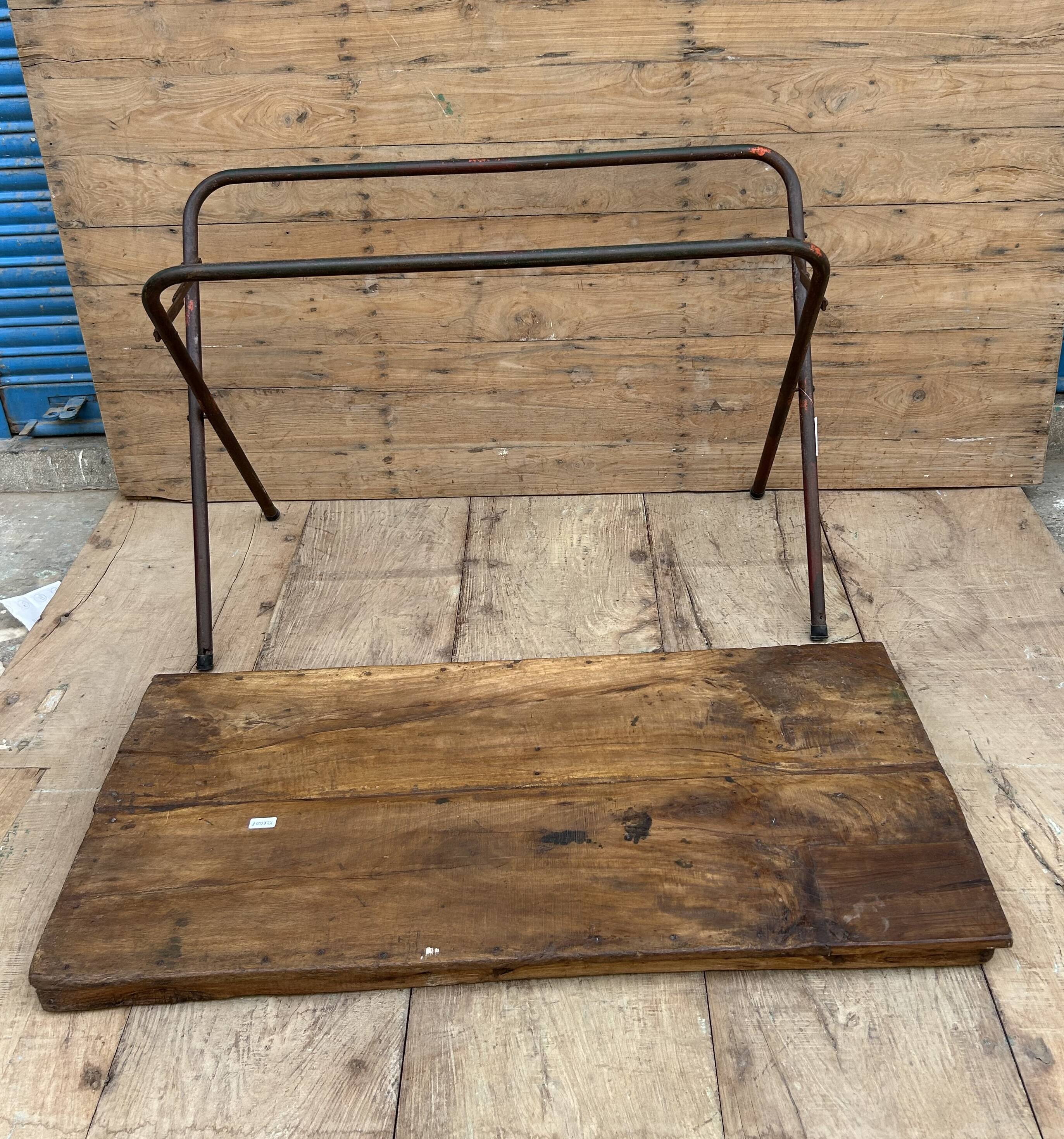 Folding workshop table with a metal frame and solid teak top.