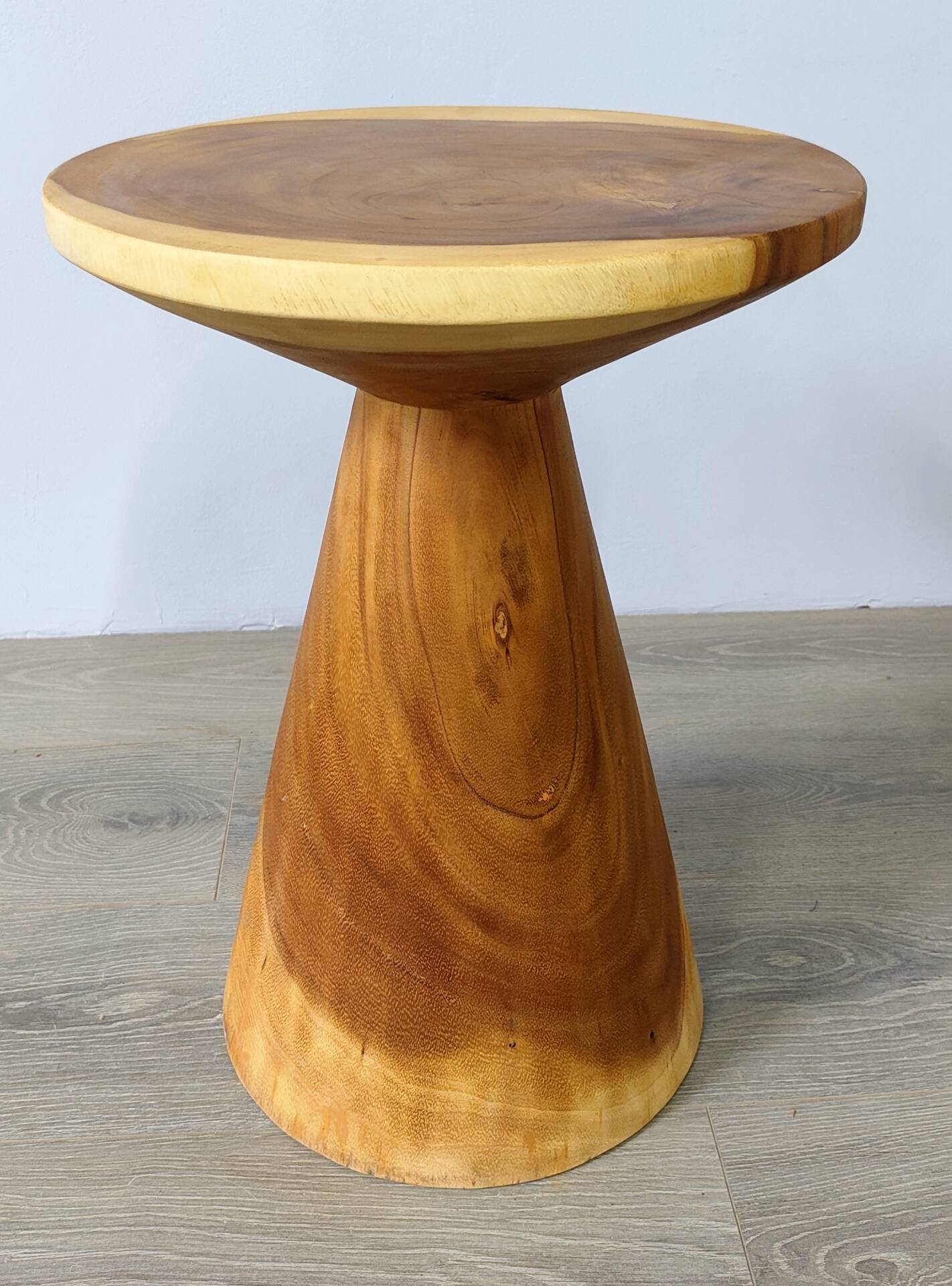 Minimalist side table in solid suar wood with conical legs.