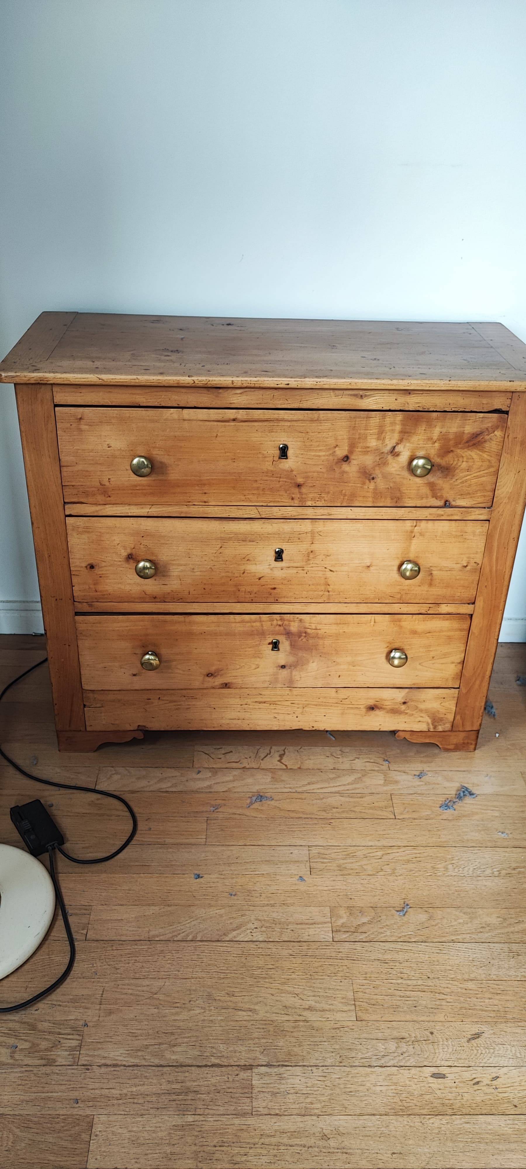 Rustic English pine chest of drawers with porcelain knobs.