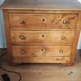Rustic English pine chest of drawers with porcelain knobs.