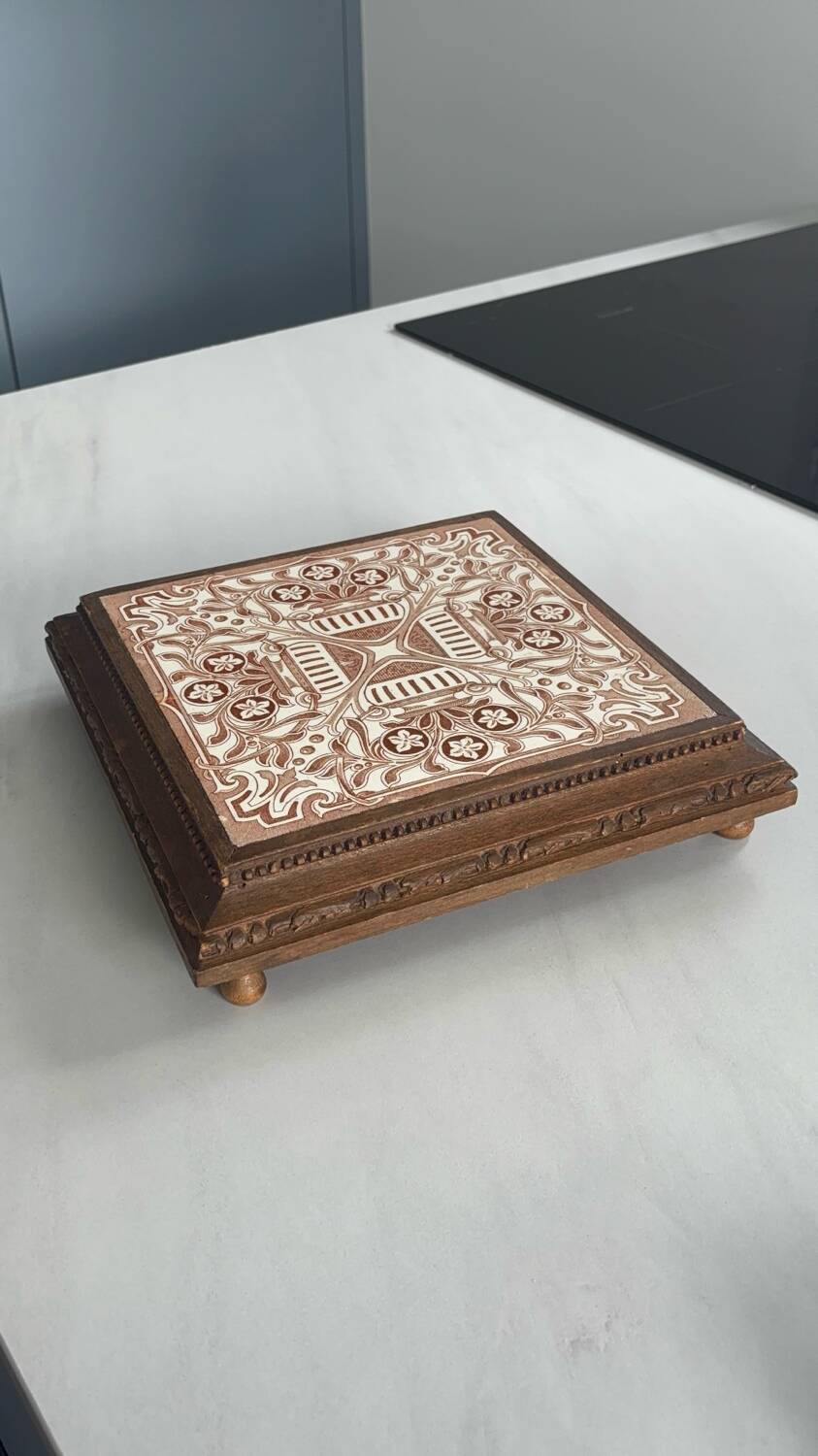 Vintage wooden and antique earthenware trivet, brown tile design