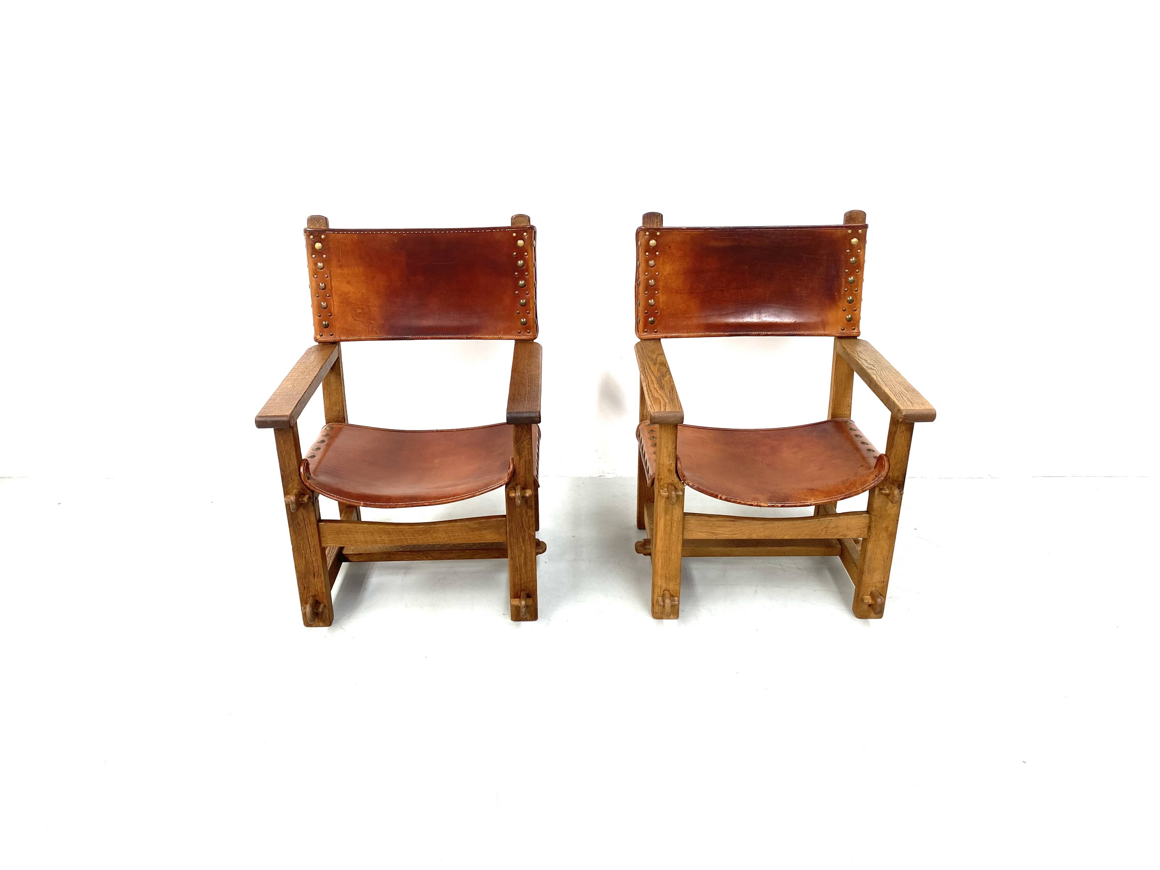 Paire de chaises de château brutalistes anciennes faites à la main en chêne et cuir cognac, années 1920.