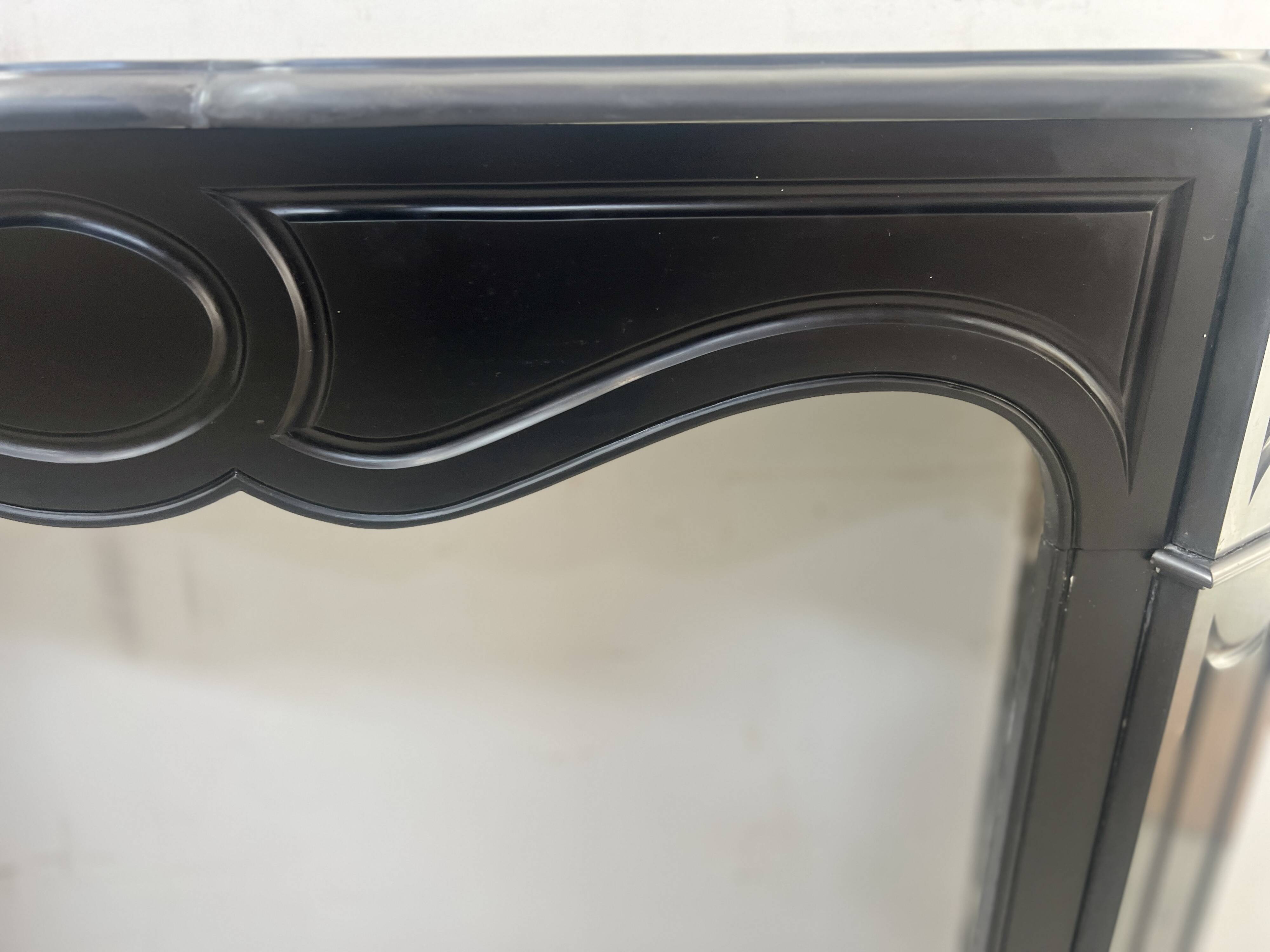 Cheminée de style Louis XV modèle Pompadour en marbre noir moucheté, XXe siècle