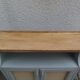 Small vintage green-grey piece of furniture, with 2 doors covered in burlap.