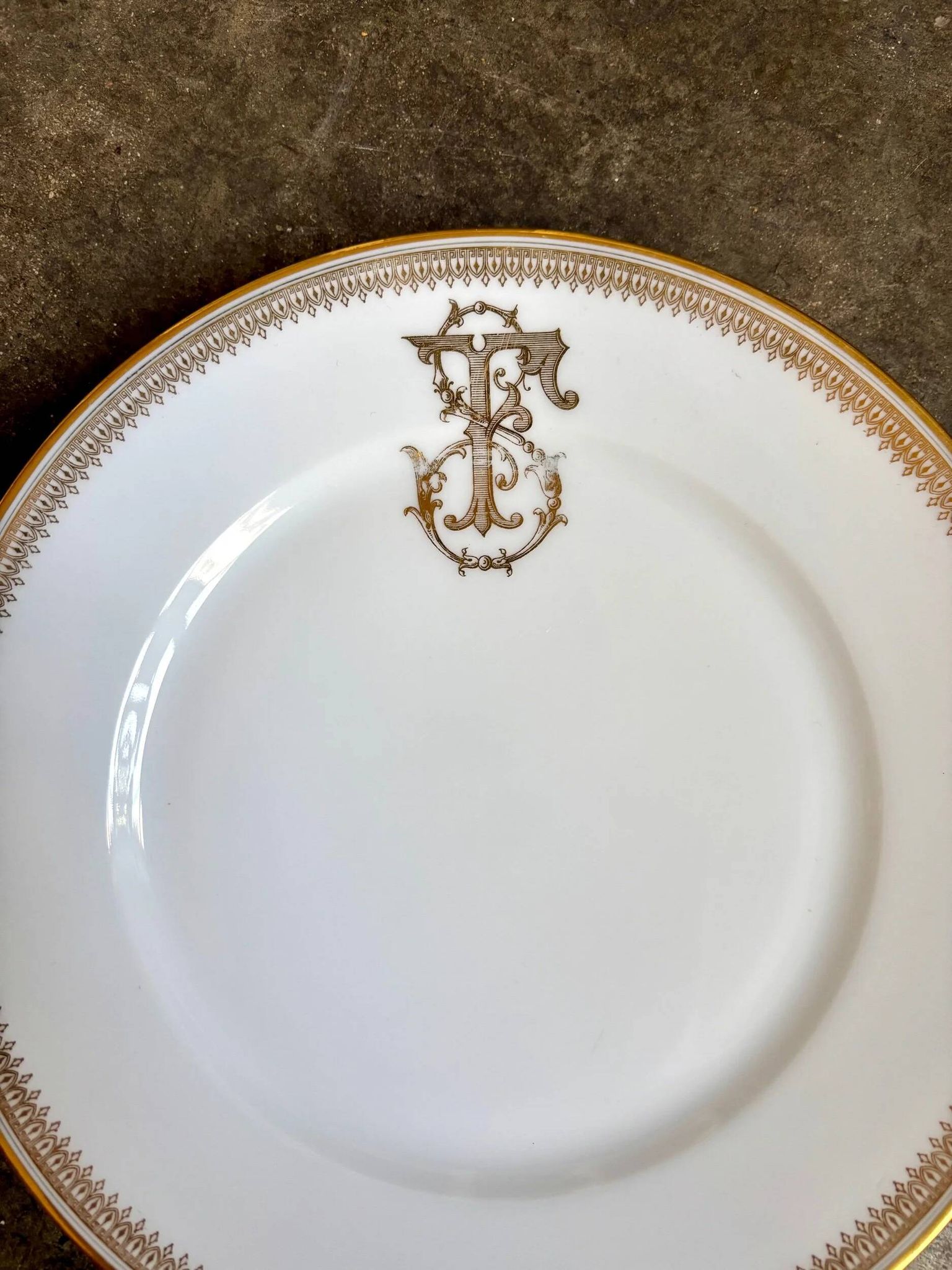 Assiette plate en porcelaine dorée monogrammée "F"