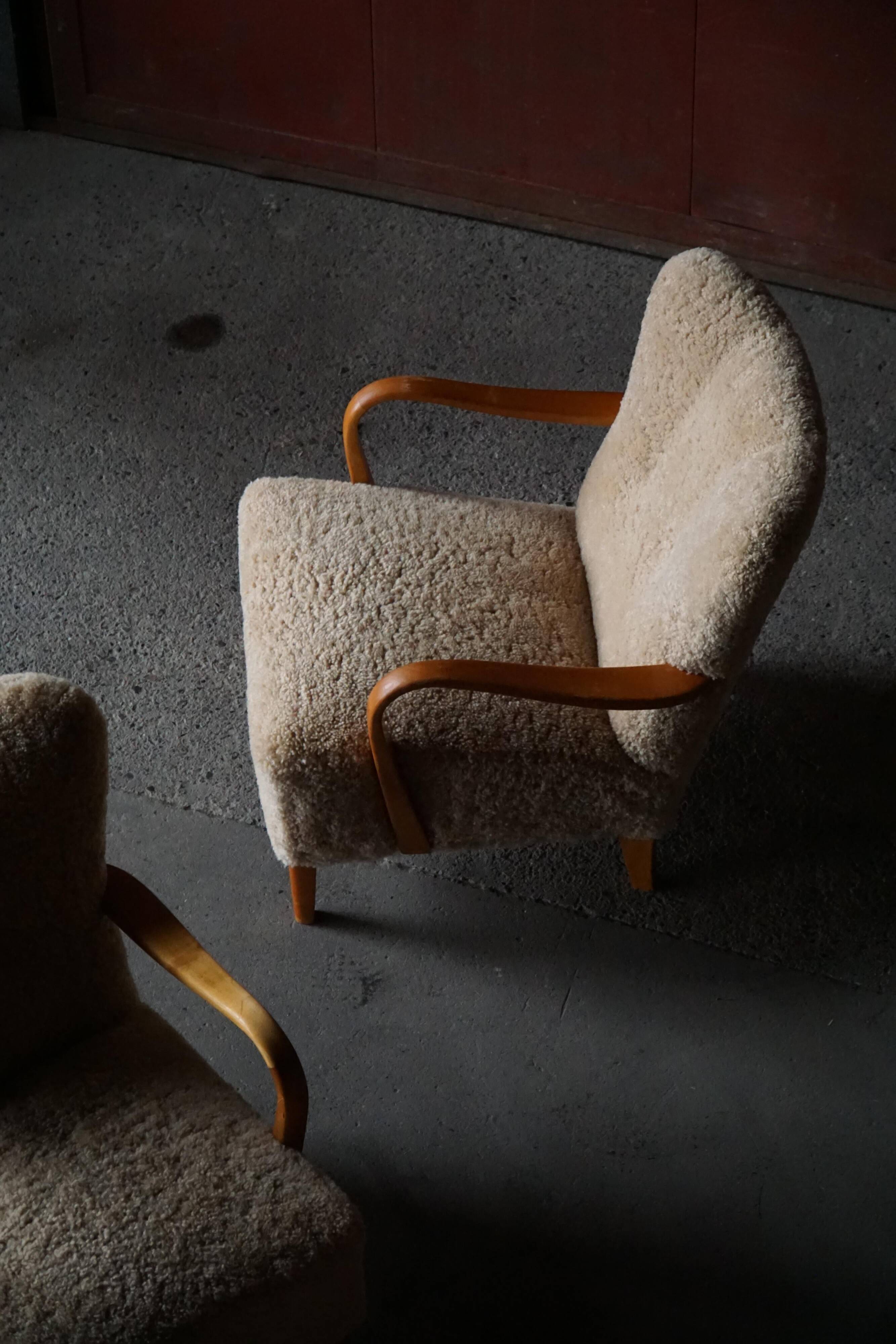 Pair of Mid Century Modern Swedish lounge chairs in birch and lamb's wool, 1960s.