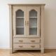 Antique beige wooden display cabinet with glass doors.