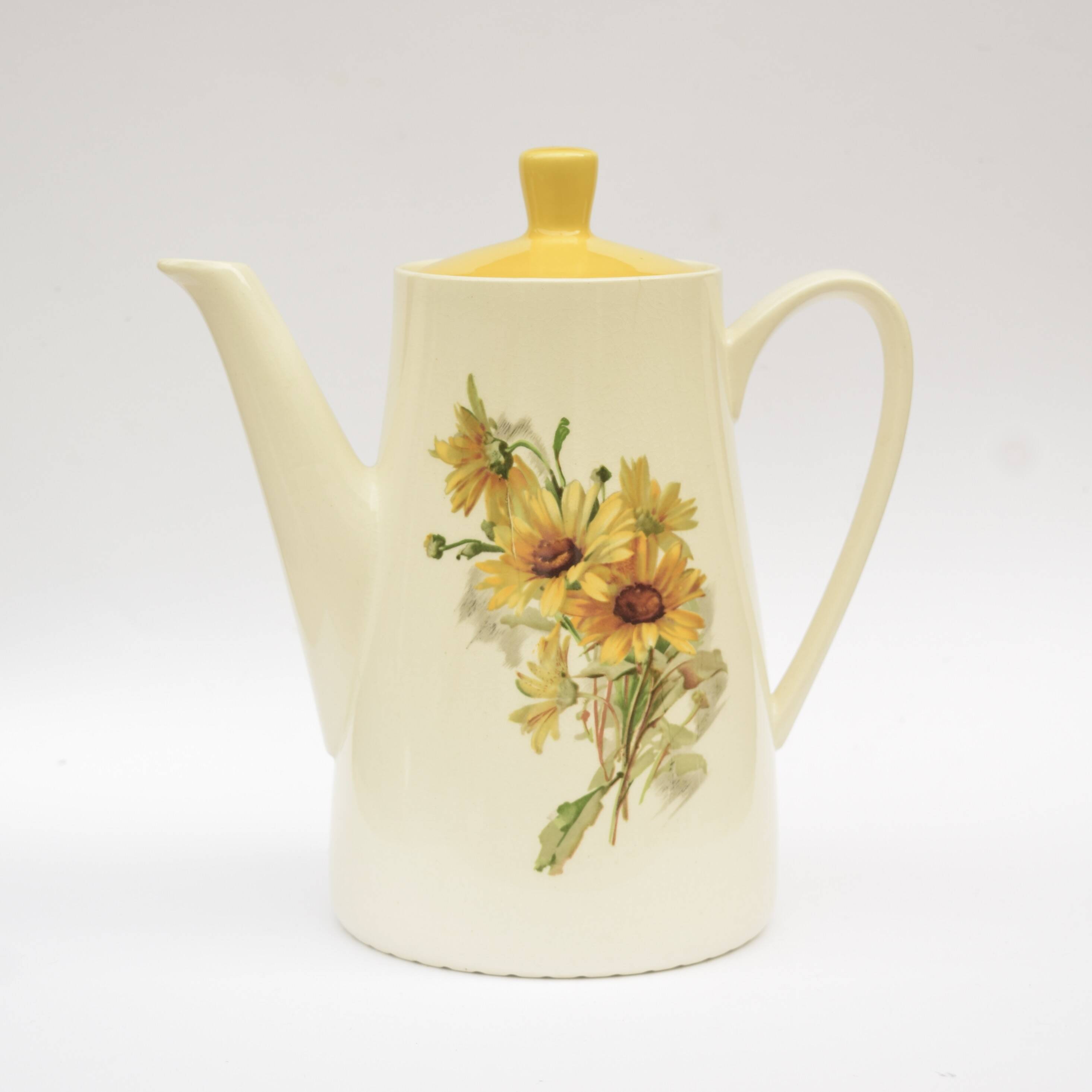 Old glazed ceramic coffee pot decorated with sunflowers