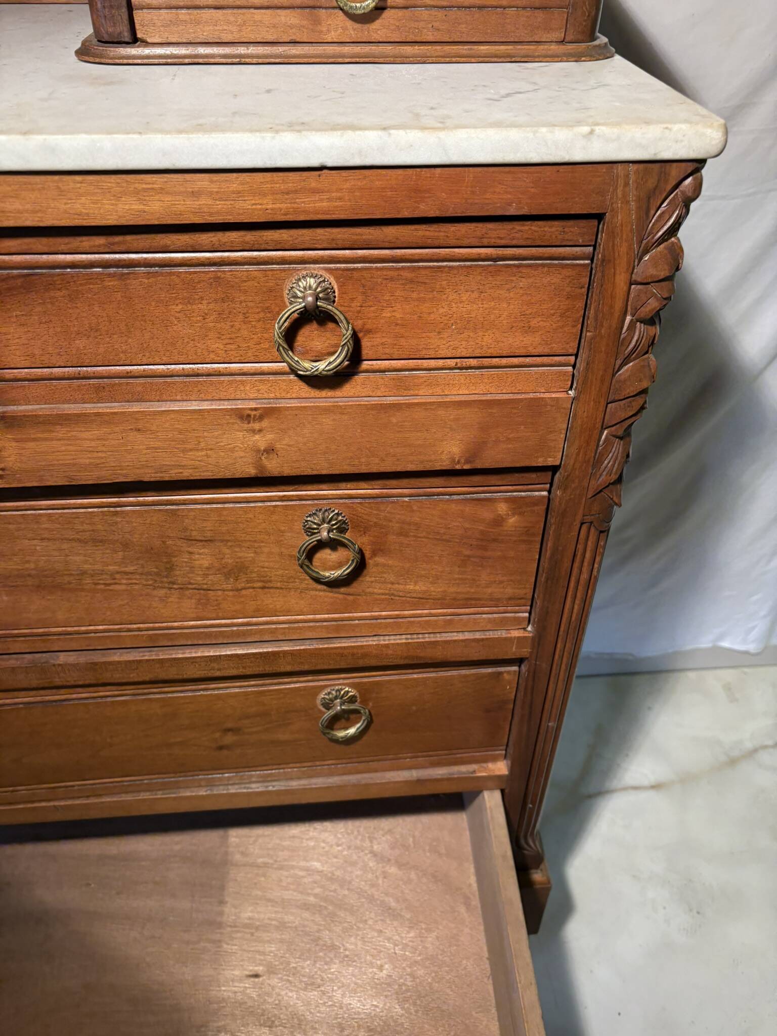 Antique carved wooden dressing table with marble and tilting oval mirror.