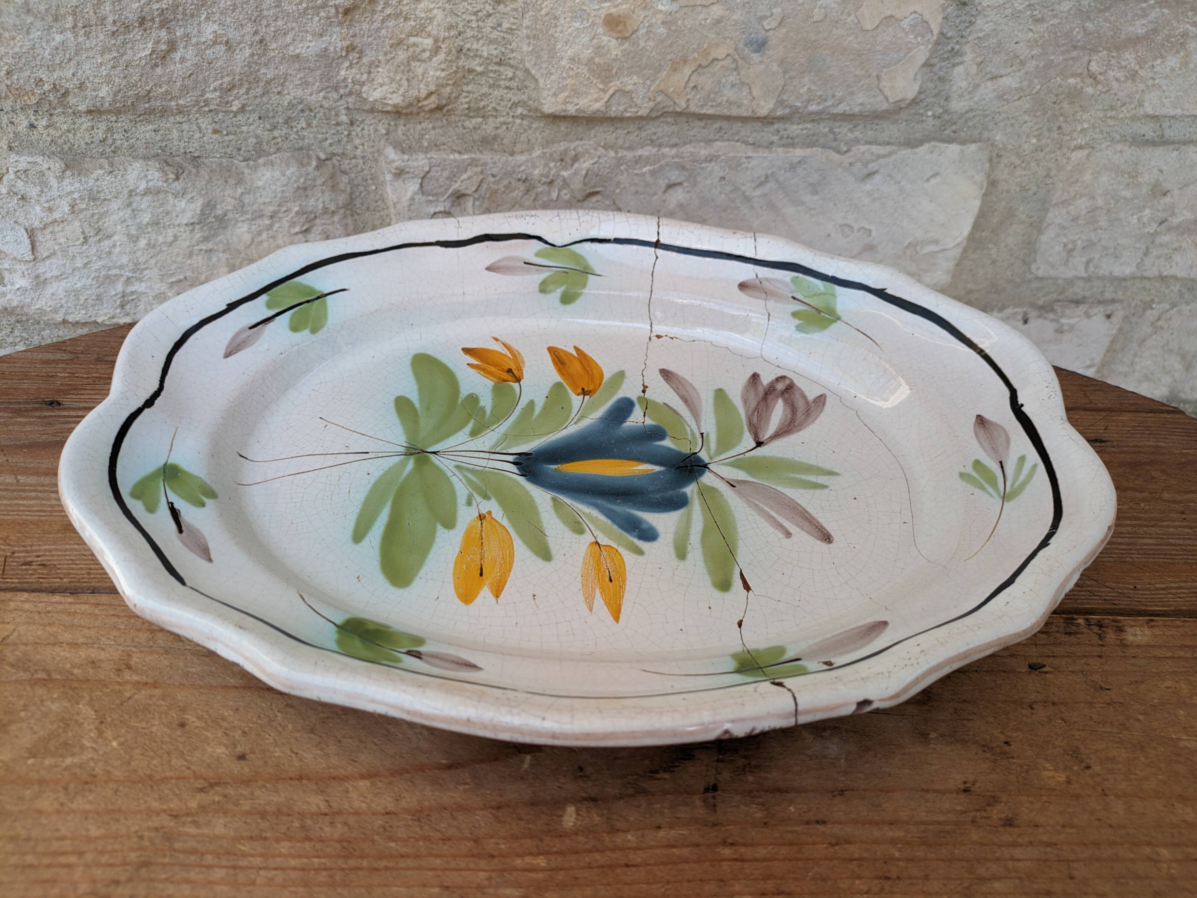 Old oval dish with floral motif called black bottom with staples