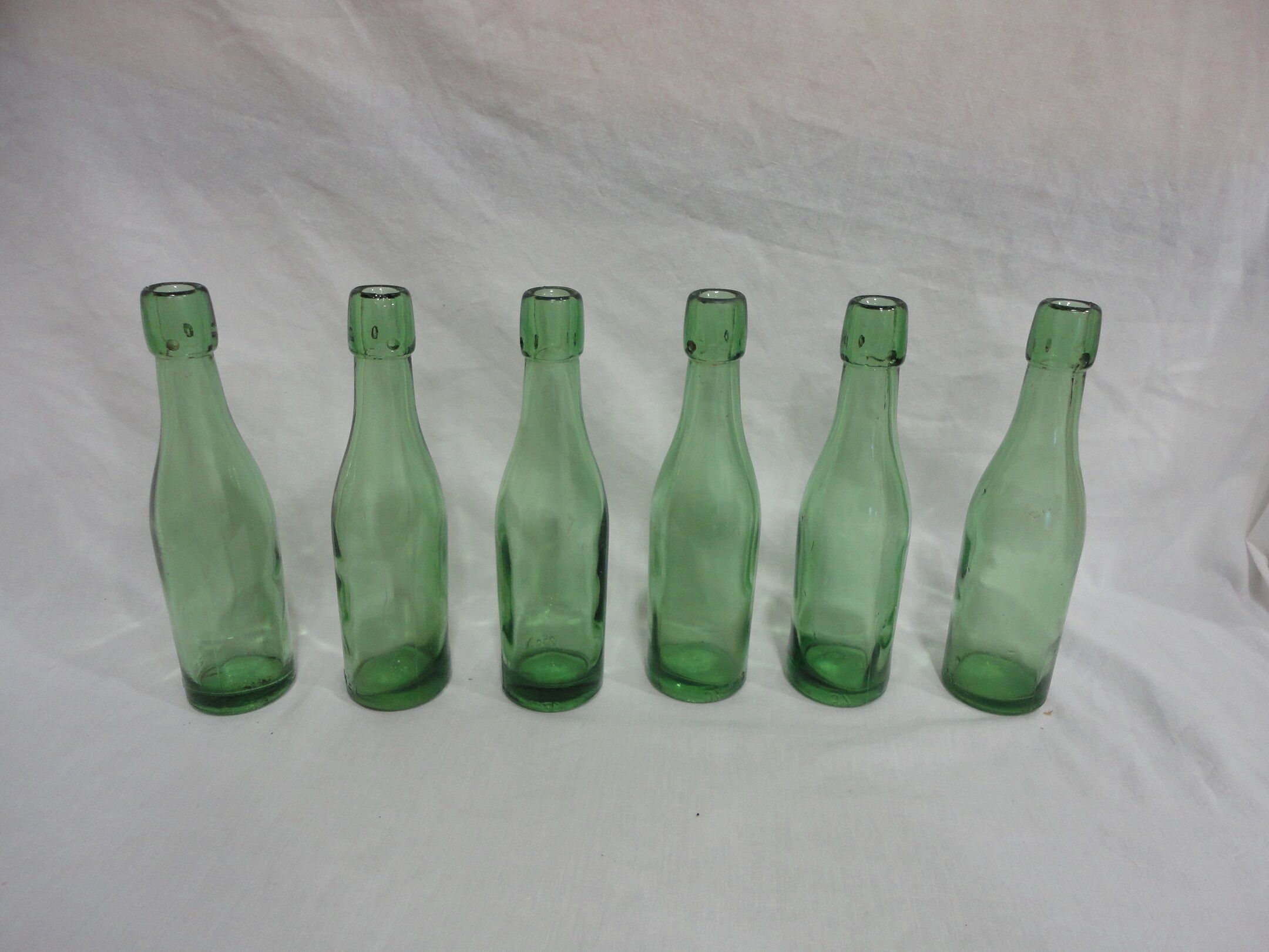 Series of 6 old glass soda bottles