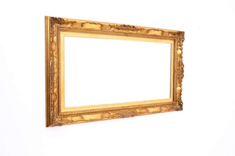 A mirror with a golden, richly carved frame.